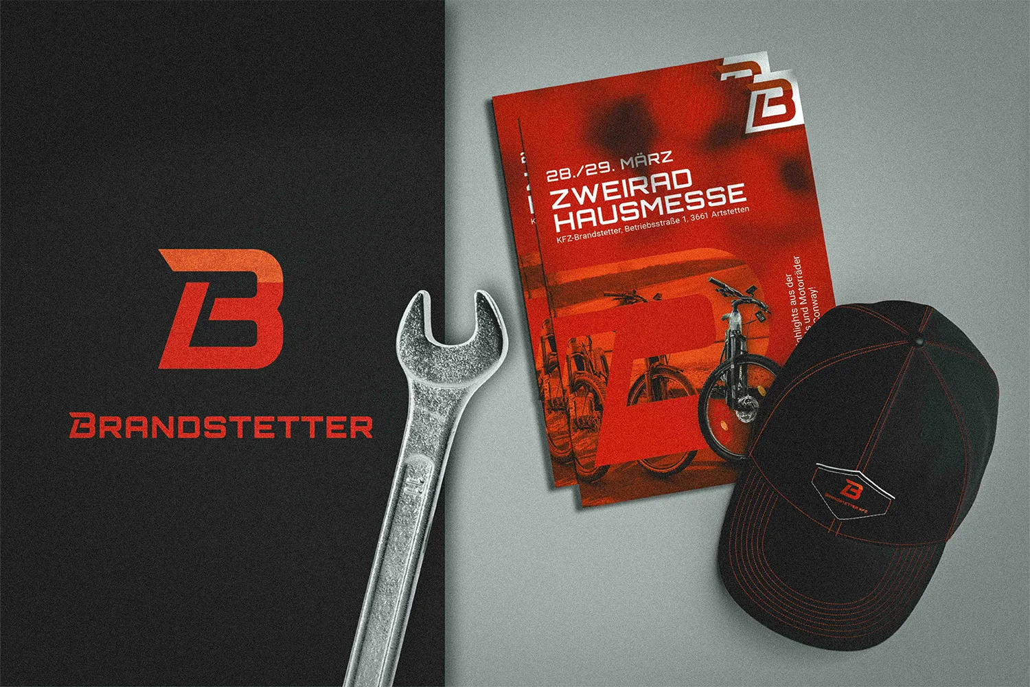 Werbematerialien von KFZ Brandstetter für eine Zweirad-Hausmesse, bestehend aus einem Plakat mit Fahrrädern, einem schwarzen Basecap mit Logo, einem Schraubenschlüssel und einem schwarzen Karton mit dem roten ‚B‘-Logo und Schriftzug ‚Brandstetter‘.